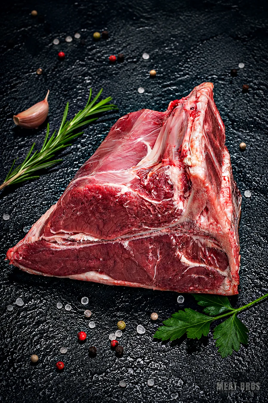 Pieza de T-bone de res con su hueso en T sobre piedra negra